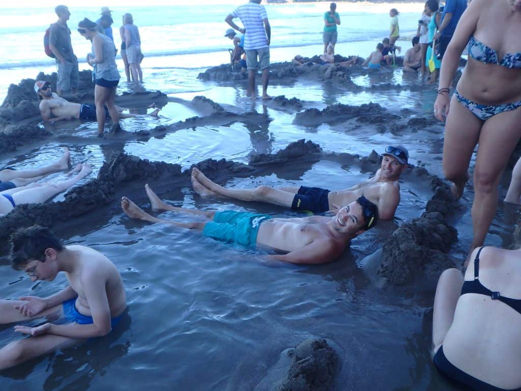 Digging a hot pool at Hot Water Beach, Coromandel